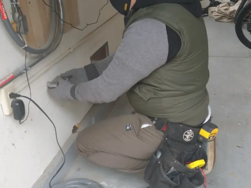 Electrician performing outlet wiring in a Uhrichsville garage